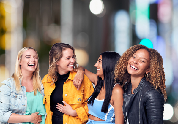 Group Studio Portrait Of Multi-Cultural Female Friends Smiling Into Camera Together