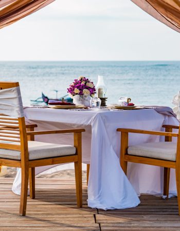 Romantic dinner setting on the beach at sunset